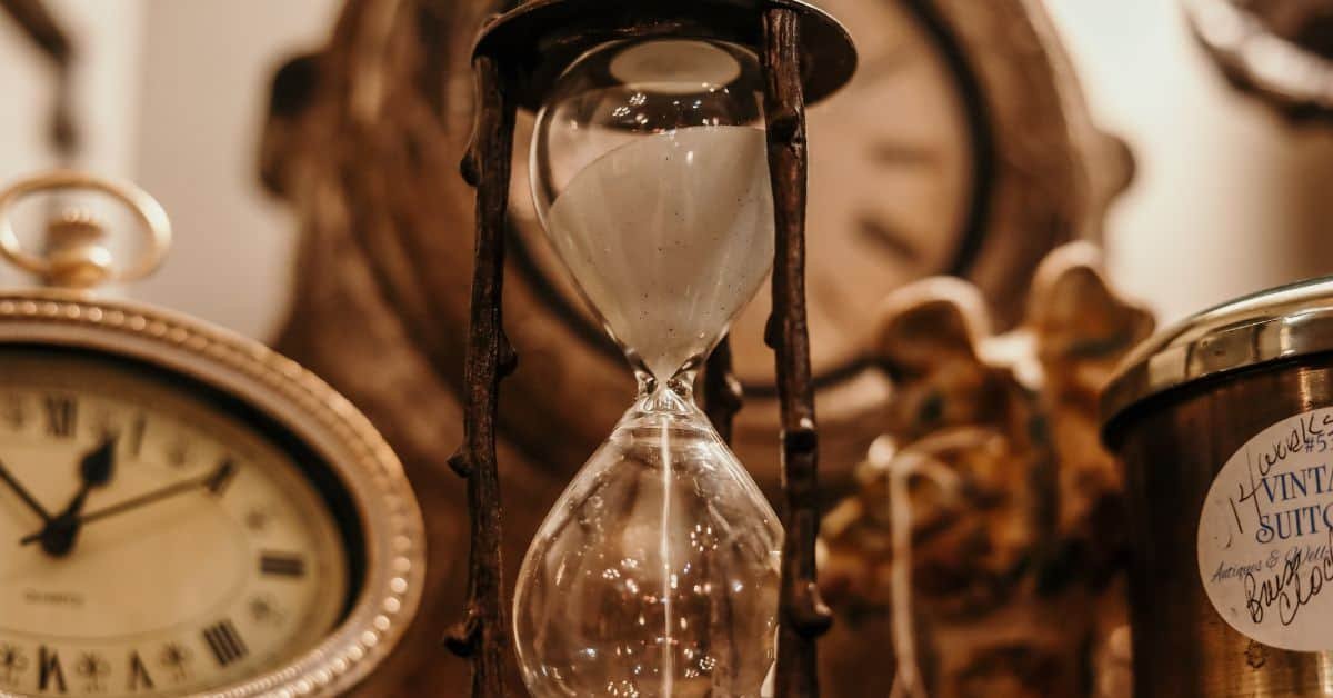 My Autistic Sense of Time Is a Fluid One - An hourglass surrounded by clocks