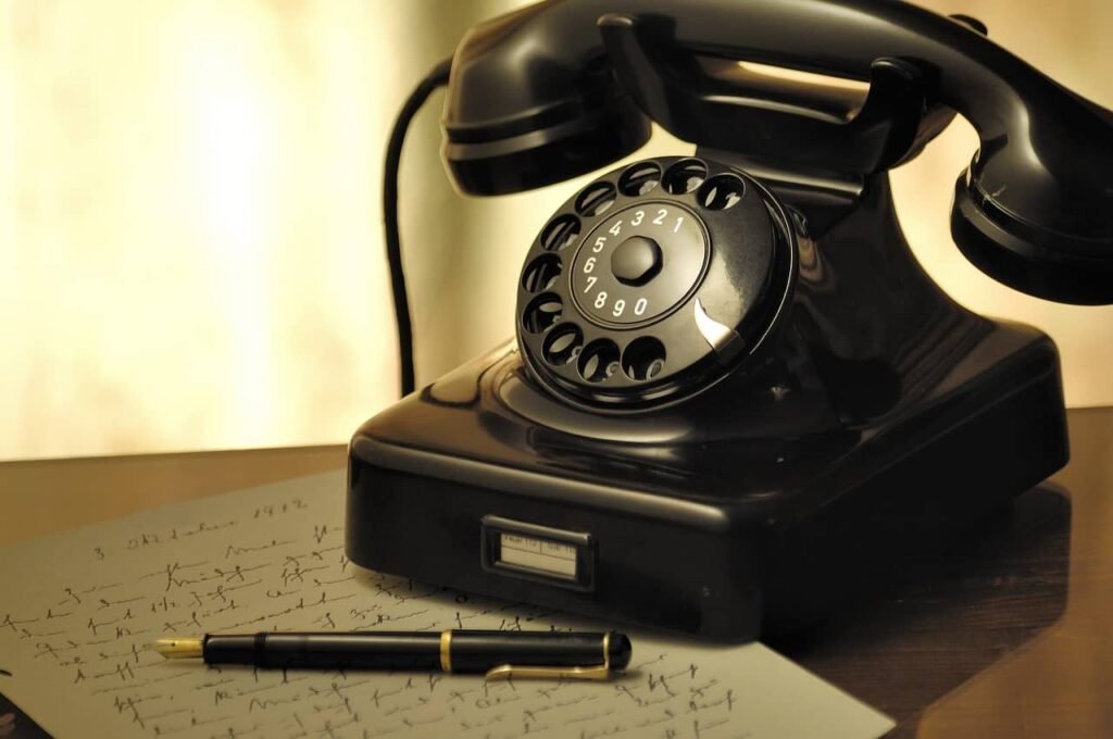 Old-fashioned telephone with a letter and a pencil on a table